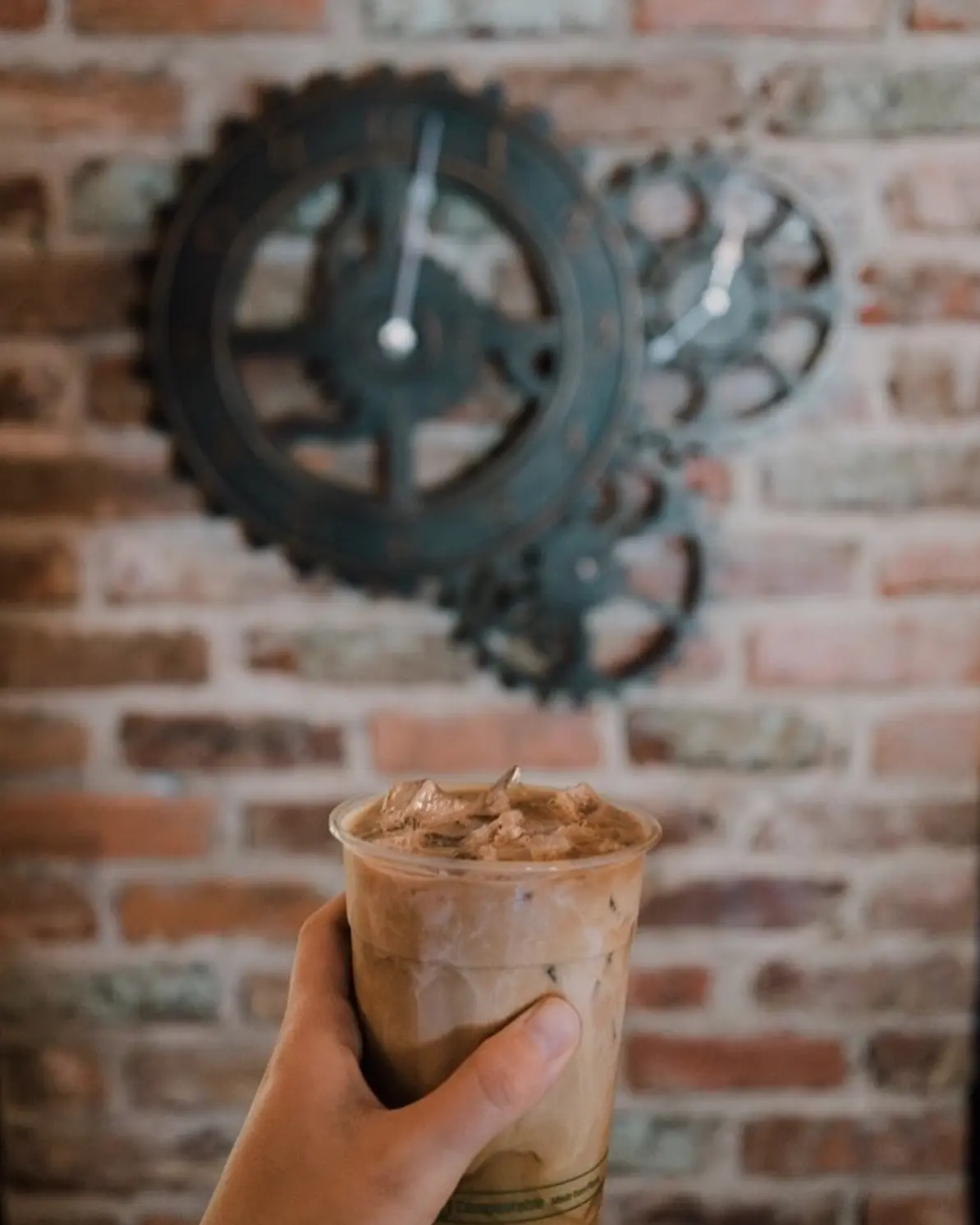 Latte in front of a gear sculpture